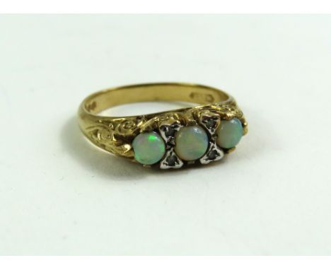 A 9ct gold opal three stone ring, with diamond point accents, finger size N 1/2, 3.2g gross