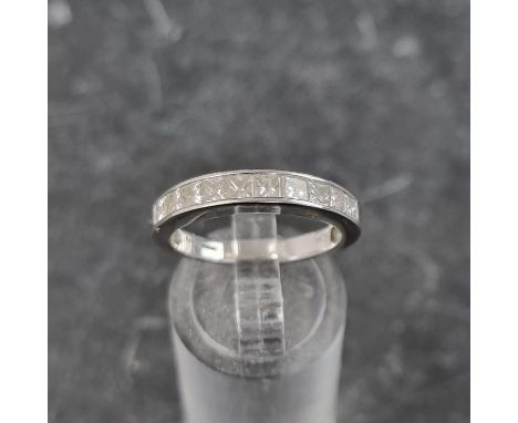 An 18ct white gold diamond half eternity ring, channel set with ten square diamonds, size N, gross weight 4g.