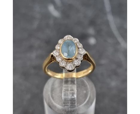 An 18ct gold aquamarine and diamond oval cluster ring, by A P H, Birmingham 2003, size K, gross weight 4.7g.