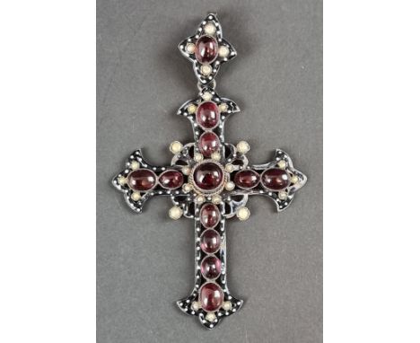 A 19th century parcel gilt Bohemian pendant cross, having enamel decoration, set with cabochon garnets and split pearls, 8cm.