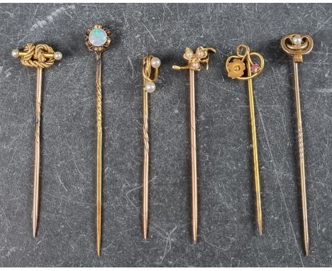 Six stick pins, four set pearls, one set opal and one set ruby.