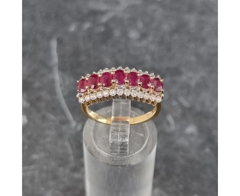 An 18ct gold ruby and diamond ring,&nbsp;set seven faceted rubies with thirteen diamonds to either side, size N1/2, gross wei