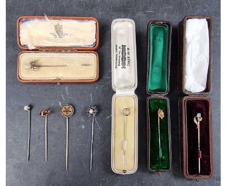 A cased Victorian yellow metal opal and seed pearl stick pin, stamped '15ct'; together with three other cased yellow metal st