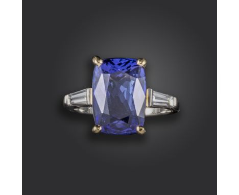 A tanzanite and diamond three-stone ring, set with a cushion-shaped tanzanite weighing approximately 8.00cts, with tapered ba