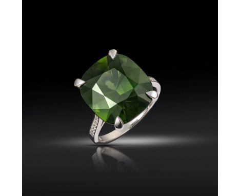 A zircon and diamond ring, the cushion-shaped green zircon weighs 13.86cts, set with graduated circular-cut diamonds to each 