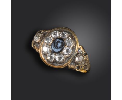 A Victorian onyx and diamond mourning ring, the oval onyx cameo set within a surround of old cushion-shaped diamonds and diam