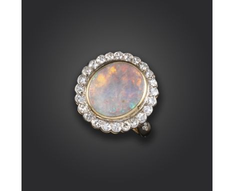 An opal and diamond cluster ring, the white opal is rubover set within a surround of single-cut diamonds, with a single-cut d