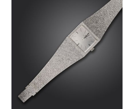 A lady's gold wristwatch by Bucherer, the signed and textured rectangular dial with baton numerals, manual movement, on textu