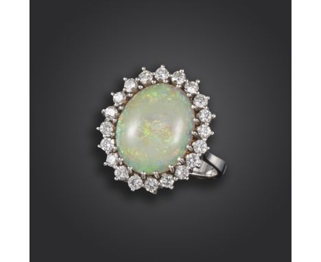 An opal and diamond cluster ring, the oval-shaped opal is set within a surround of round brilliant-cut diamonds in white gold