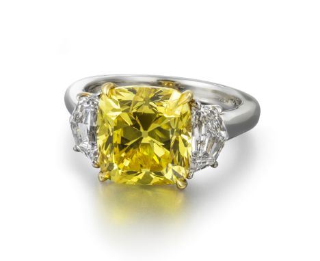 A fancy vivid yellow and white diamond three-stone ring, the cushion-shaped diamond weighs 5.26cts, set with two fancy-shaped