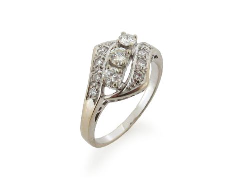 A diamond cluster ring, the three graduated round brilliant-cut diamonds are set within a diamond crossover surround in white