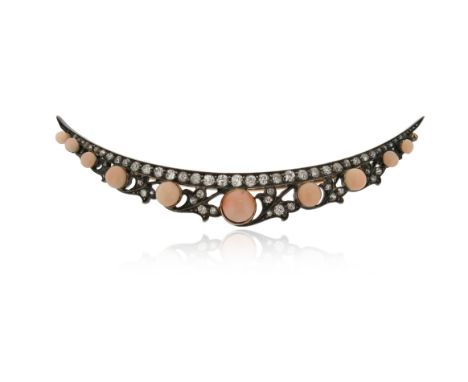 λ A Victorian coral and diamond open crescent brooch, set with graduated coral cabochons within stylised ivy leaves and a bor
