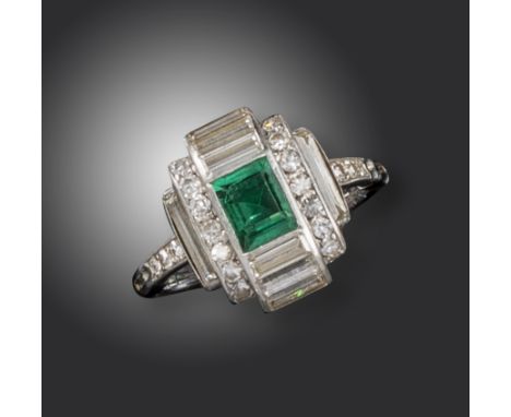 An Art Deco emerald and diamond ring, centred with a baguette-shaped emerald between six baguette-shaped diamonds, seven smal