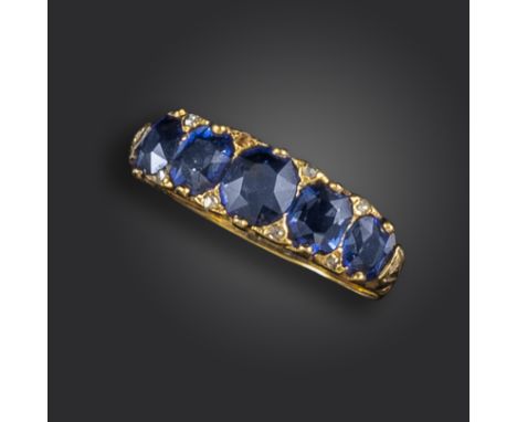 A Victorian sapphire half-hoop ring, the graduated cushion-shaped sapphires set with diamond pointers in carved and pierced y