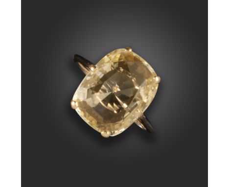 A sapphire solitaire ring, the cushion-shaped yellow sapphire claw-set in yellow gold, size L