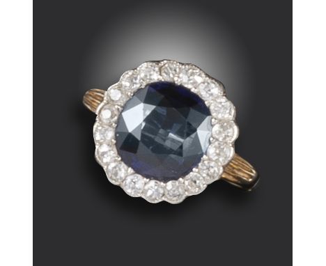 A Victorian sapphire and diamond cluster ring, the cushion-shaped sapphire set within a surround of old circular-cut diamonds