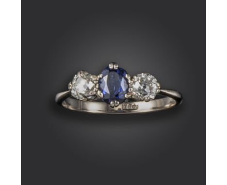 A sapphire and diamond three-stone ring, set with an oval-shaped sapphire between old cushion-shaped diamonds in white gold, 