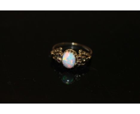 A 9CT GOLD OPAL SET RING WITH FOUR SMALL RUBIES TO SHOULDERS 