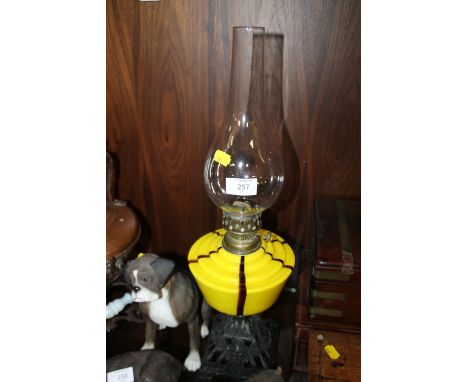 A VINTAGE YELLOW GLASS OIL LAMP WITH CAST BASE