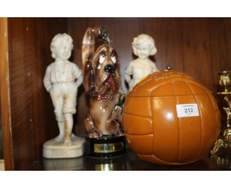 A NOVELTY CERAMIC 'THE LAST SHOT' DECANTER TOGETHER WITH A PAIR OF BISQUE STYLE CHILDREN FIGURES AND A 1966 LIDDED FOOTBALL C