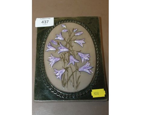 A SWEDISH CERAMIC WALL HANGING TILE DEPICTING PURPLE FLOWERS 