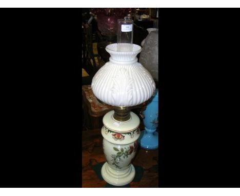 A floral decorated oil lamp with embossed milk glass shade
