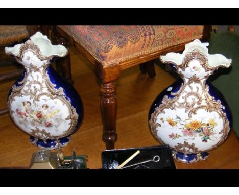 A pair of 42cm high Victorian ceramic vases with winged cherub and flower decoration 