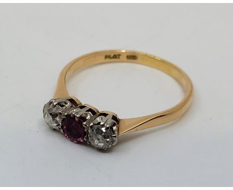 An 18ct. gold, platinum, diamond and ruby ring, set round mixed cut ruby to centre flanked by old-cut diamond to either side 