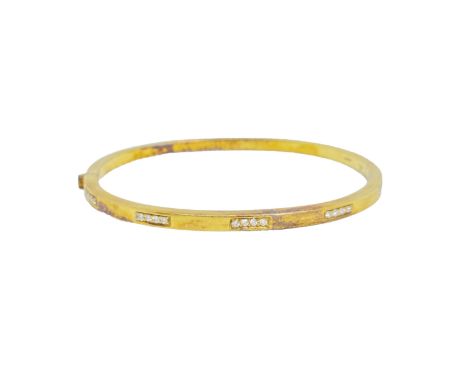 British Circa 1980 A diamond and 18 carat yellow gold bangle The plain heavy yellow gold bangle set to the top with sections 