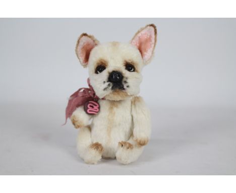 Unknown Maker - A French Bull Dog with glass eyes, plastic nose, and pink ears. Dog has a pink bow-tie with a plastic donut a