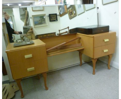 A 1980s light oak dressing table, surmounted by a mirror, over four drawers, raised on turned legs  62''h  60''w        CA