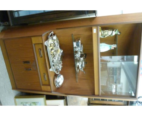 A G-plan teak and exotic hardwood corner cabinet, having twin glass sliding doors, a shelf, a drawer and a pair of doors, on 