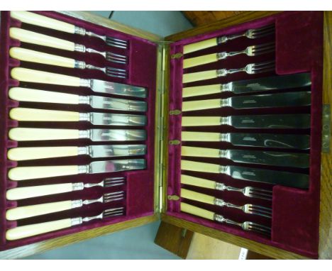 A set of twelve Elkington & Co silver plated dessert knives and forks on ivory handles, in a dedicated mushroom coloured, fab