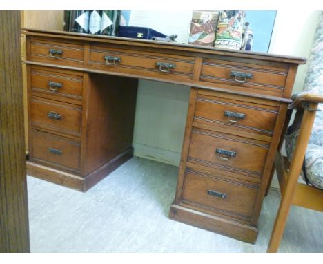 An Edwardian walnut nine drawer, twin pedestal desk, on a plinth  29''h  48''w        BL