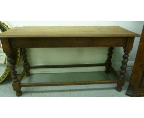 A 1930s oak bench style table, raised on barleytwist block legs  19''h  35''w         BSR