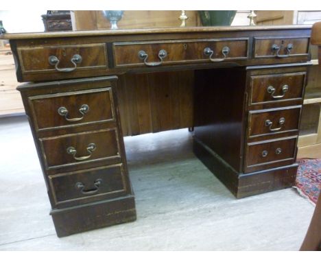A modern mahogany finished, nine drawer, twin pedestal desk, the top set with a green hide scriber, raised on bracket feet  3