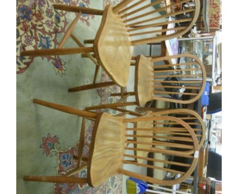A set of four mid 20thC lacquered light beech and elm framed Windsor chairs, each having a hoop and spindle back, the solid s