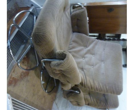 A pair of 1960s chromium plated tubular steel framed chairs, each having a high, level back and enclosed arms, button upholst