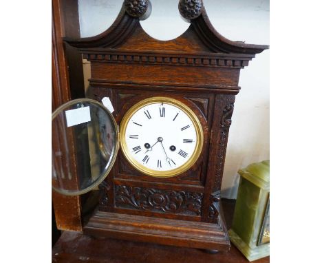 Victorian carved oak mantle clock with swan neck pediment having French movement, striking on a gong, 15" high