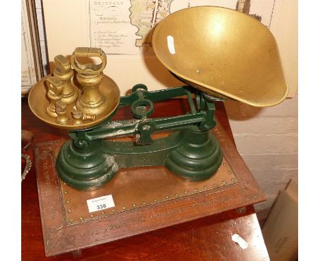 Old brass iron kitchen scales with bell weights standing on a carved wood and copper presentation stand awarded to a 1930's h