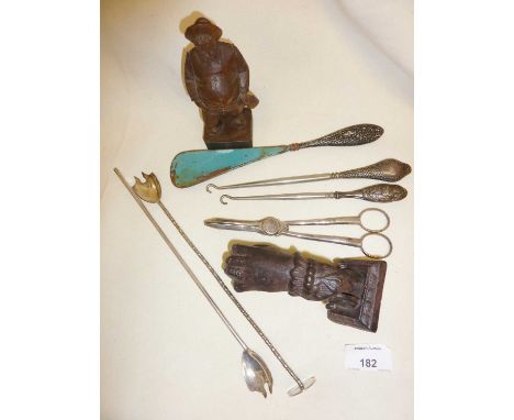 Anri carving of man, silver handled button hooks and shoe horn, cocktail stirrers, grape scissors and a door knocker in the s