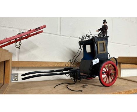 A scratch built model of a Victorian carriage painted in black with red wheels together with a driver figure, 46cm long