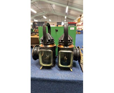 A pair of vintage iron, brass and copper mounted traction engine lamps with bullseye glass and looped handles, 35cm high appr