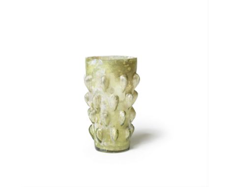  A Roman yellowish-green glass 'lotus bud' beaker Circa late 1st Century A.D.Of cylindrical tapering form, with flat ground r