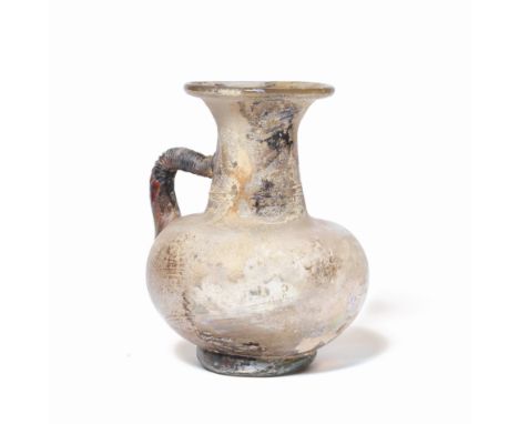  A large Roman pale yellow glass jug  Circa 2nd-4th Century A.D.The bulbous body set on an applied thick green glass coiled b