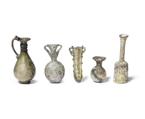  Four Roman glass vessels   Circa 2nd-5th Century A.D.Comprising a sprinkler flask, the mould blown body with repeat chevron 