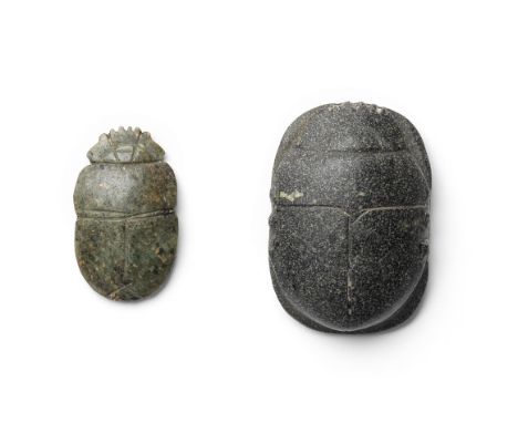  Two Egyptian uninscribed stone scarabs Third Intermediate Period, circa 1069-664 B.C.The larger of dark speckled grey stone,