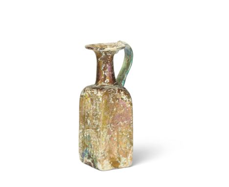  A Byzantine amber rectangular glass jug Circa 6th-7th Century A.D.With funnel mouth with infolded rim and green strap handle
