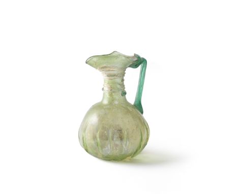  A Roman light green glass jug  Circa 4th Century A.D.With trefoil lip and spiral trail decoration around the cylindrical nec