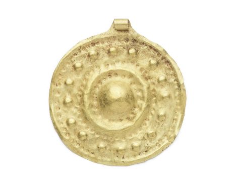  A Western Asiatic gold disc pendant Circa mid-late 2nd Millennium B.C.With a large central boss encircled by concentric ring